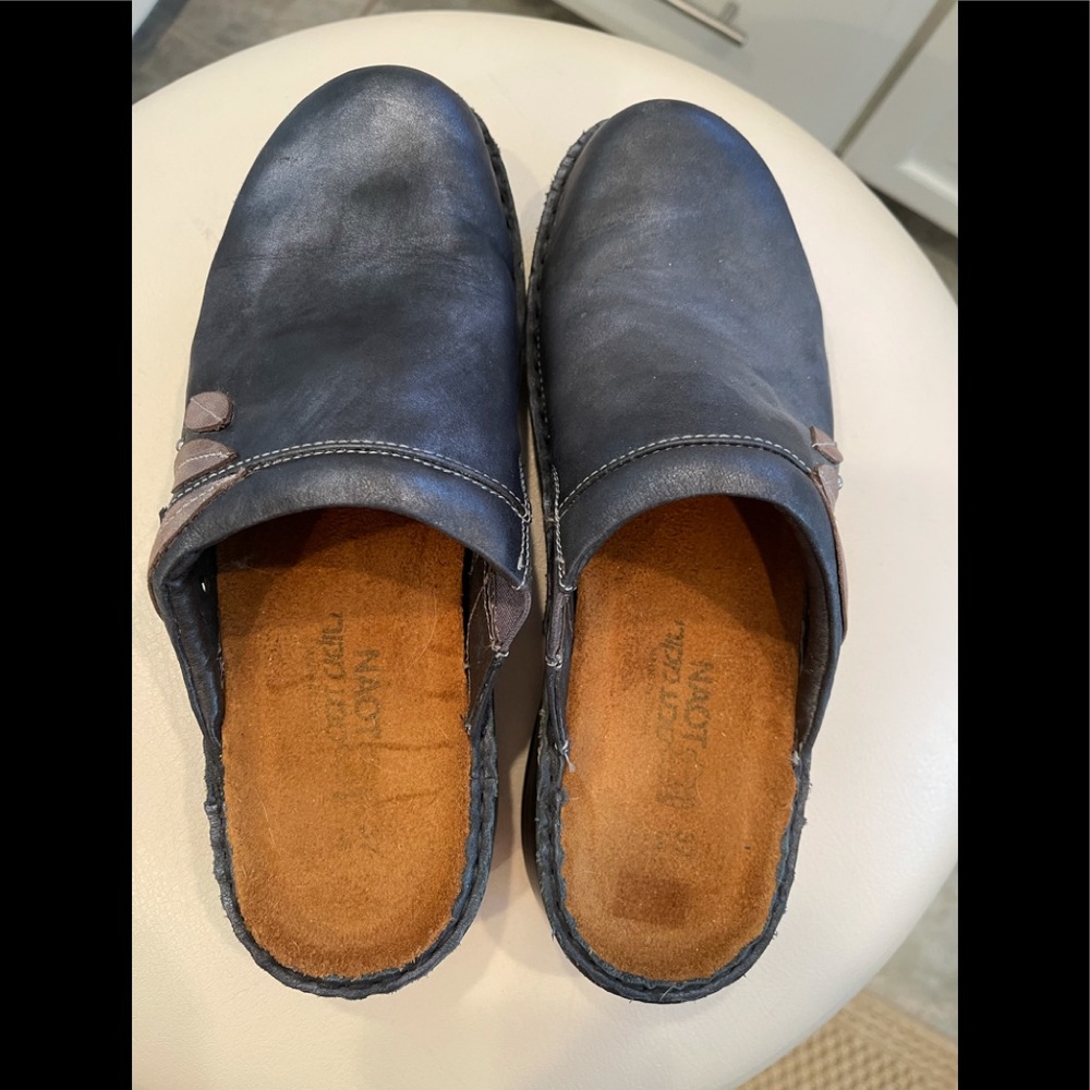 Naot leather slip on mules with fabric leaf appliqué.